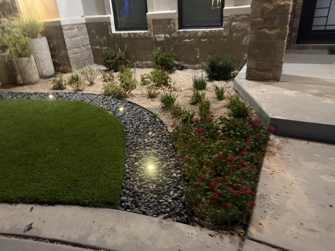 Finished turf and rock landscaping with nighttime accent lights